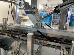 UBL cartoning machine precision mechanical assembly - Adjustable metal components and calibration scale, designed for accurate setup in automated packaging line operations