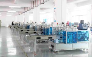 UBL’s glue-spray cartoning machines neatly arranged in the production workshop: The stainless-steel and blue-enclosed glue-spray cartoning equipment is lined up orderly, ready for quality inspection and shipment