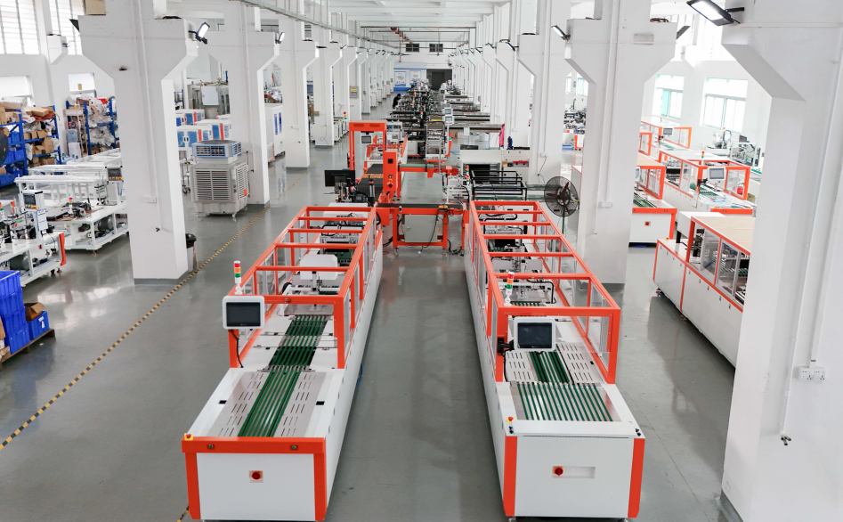 UBL’s garment folding machine production workshop: Red-and-white enclosed garment folding machines (equipped with conveyor belts and control screens) are neatly arranged in the spacious, organized production facility, prepared for functional testing and customer delivery