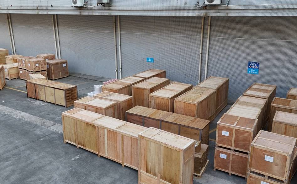 UBL’s industrial equipment packed for shipment: A large quantity of UBL’s intelligent equipment (encased in sturdy wooden crates) is neatly arranged at the loading area, fully prepared for delivery to clients