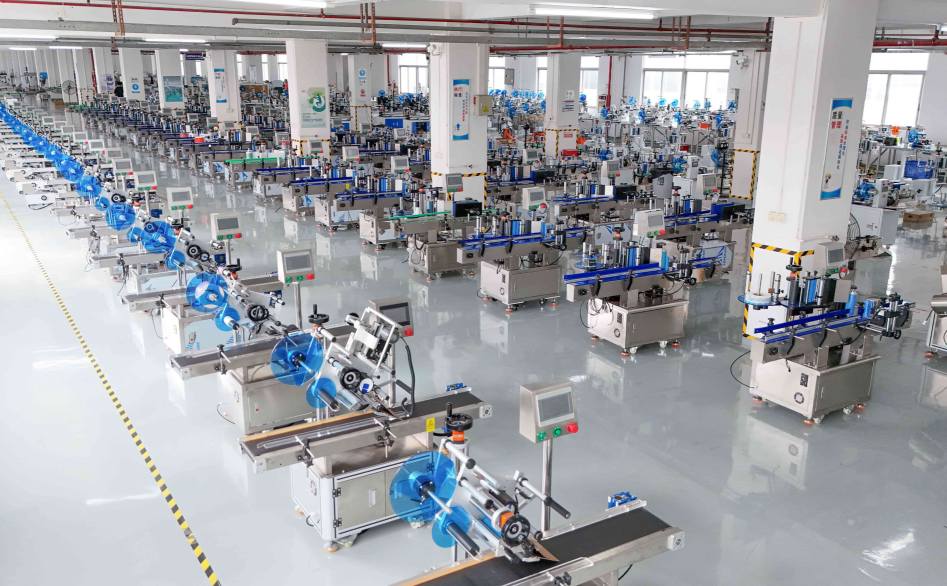 UBL’s labeling machine production workshop: A large number of intelligent labeling machines (fitted with blue label rolls) are neatly arranged in the spacious, bright production facility, ready for quality verification and customer shipment