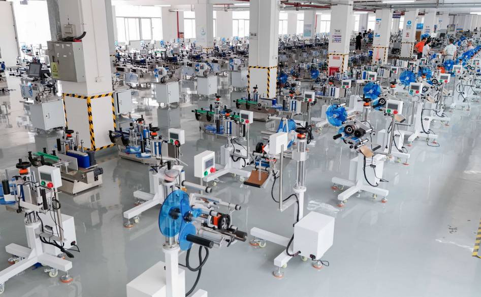 Top-down view of UBL’s labeling machine production workshop: Numerous intelligent labeling machines (equipped with blue label rolls) are neatly arranged in the bright, clean production facility, prepared for quality inspection and shipment