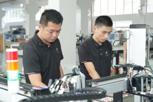 Operators adjusting a carton folding machine to improve uptime, reduce MTBF and lower total cost of ownership (TCO)