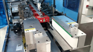 Pre-packaged coffee sticks are being ejected by the cartoning machine.