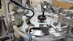 Vertical cartoner interior detail - rotating platform, carton holders, and automated control components for stable product packaging