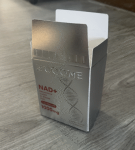 Premium metallic silver beauty packaging box for a skincare supplement, showcasing embossed branding and bold red product details for a luxurious look.