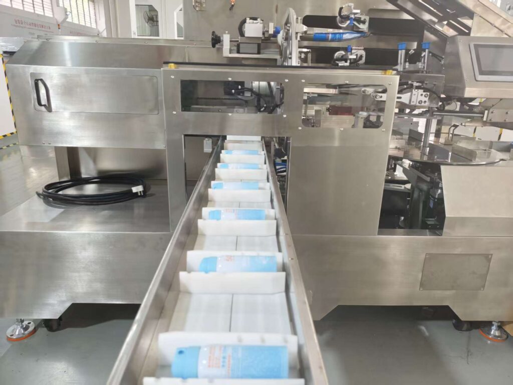 Automated rotary pouch packing system for personal care products, transporting product bottles to the packaging station.