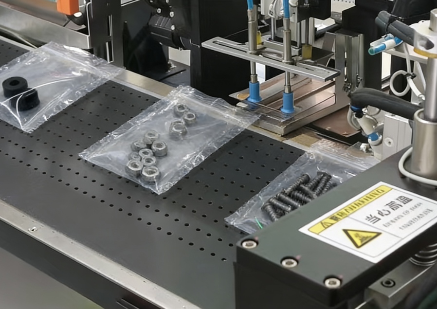 An automatic bagging machine performing automatic packaging of metal hardware parts, including nuts and screws, on a production line.