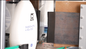 Cosmetics labeling machine applying precision labels to glass perfume bottles and skincare jars on an automated production line