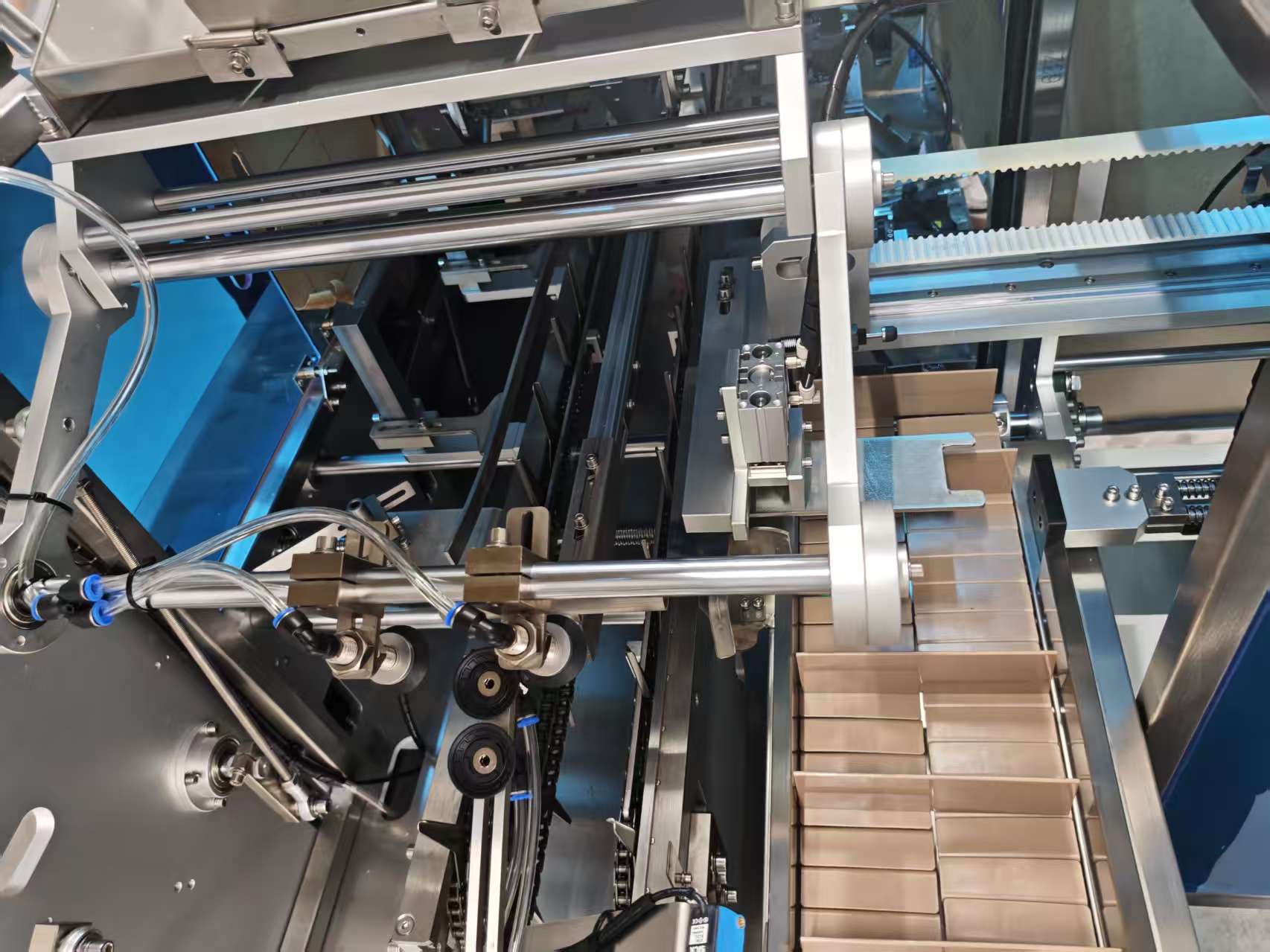 Close-up of a modular cartoning machine internal structure, showing precision mechanical components, carton feeding rails, and automated packaging mechanisms for efficient, flexible production lines.