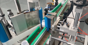 Automatic round bottle labeling machine applying labels to beverage bottles on a production line