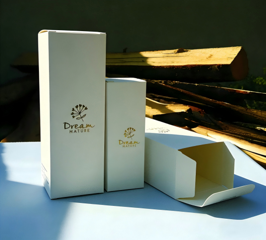 Two white cosmetic packaging boxes lying flat: one perfectly sealed, one slightly open at the top, demonstrating manual packaging inconsistency and the need for automated cartoning machines