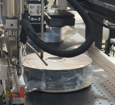 Spool Packaging Machine sealing a 3D filament spool in a plastic bag during the packaging process