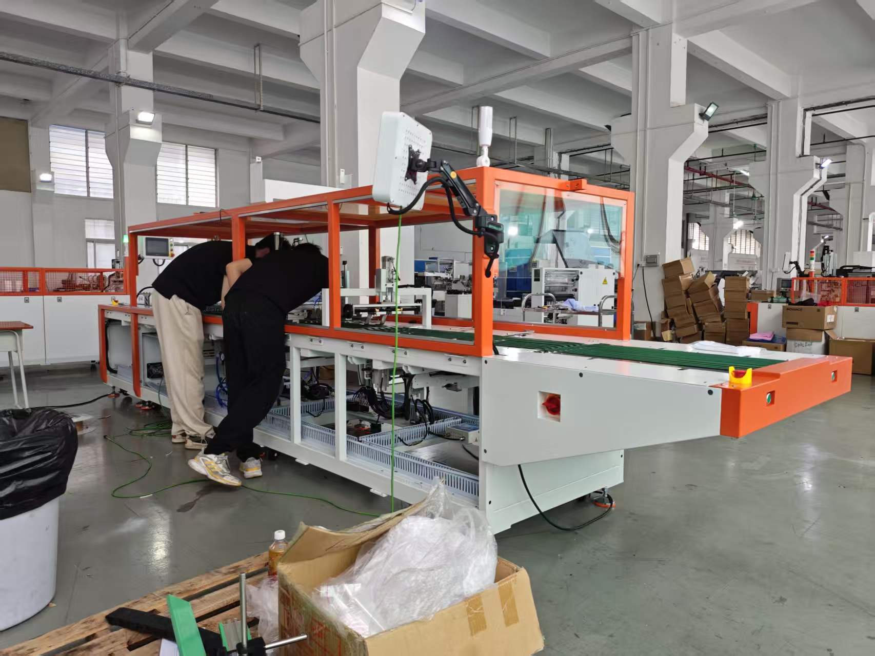 UBL technicians assembling a garment folding and packaging machine in the factory workshop