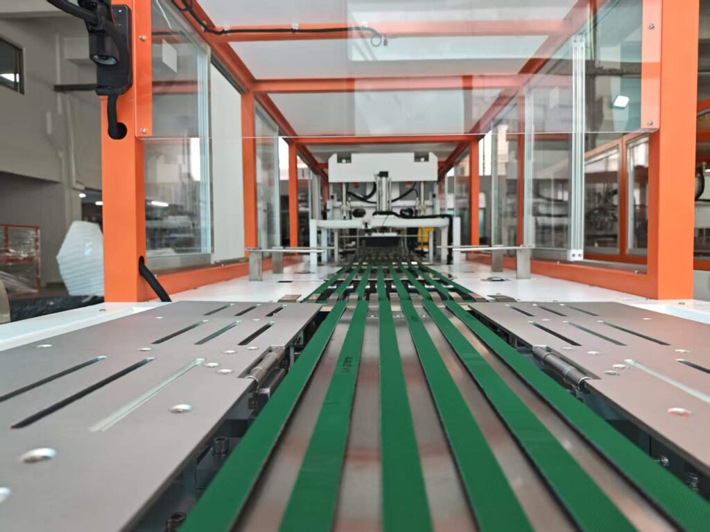 Close-up view of the internal conveyor system of an automatic clothes folding packaging machine, showing the garment feeding belts and folding mechanism.