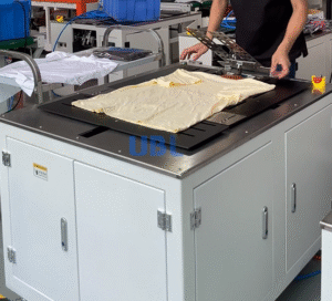 UBL single-station semi-automatic clothes folding machine, compact and small-sized, for efficient garment folding in small-scale production.
