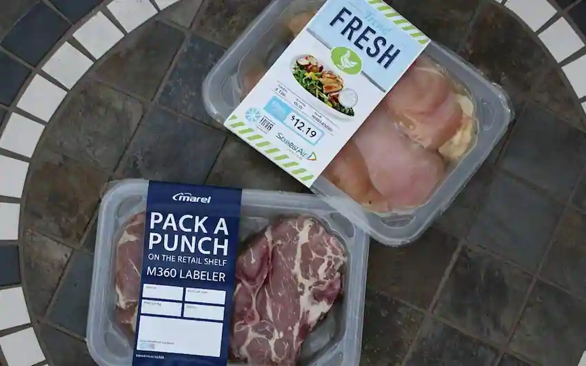 UBL flat surface labeling machine applying custom product and price labels to fresh food trays and meat packaging