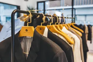 Professional men's suits and apparel in a retail boutique, showcasing the high-quality presentation enabled by UBL packaging solutions for the clothing industry.