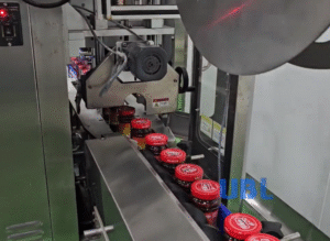 Auto bottle mouth film wrapping machine on sauce packaging line, sealing protective film for chili sauce glass bottles, high hygiene food packaging machinery