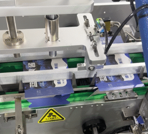 UBL hot melt glue cartoning machine seals blueberry sauce cartons by spraying hot glue