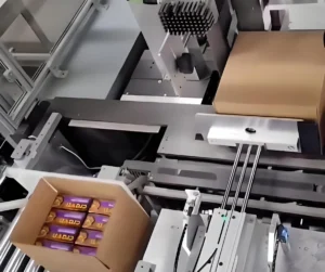Side load case packer, horizontally pushing chocolate product cartons into shipping box, automatic packaging machine for rigid products, high speed horizontal case packing system