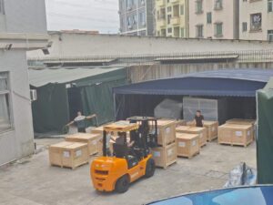 Factory loading scene, forklift handling wooden export crates of packaging machinery, showing equipment shipment for overseas clients, illustrating total landed cost for imported packaging machines including freight, duty and commissioning
